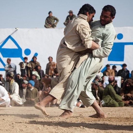 Two Afghan men compete at a traditional wrestling tournament in Zhari district in 2011