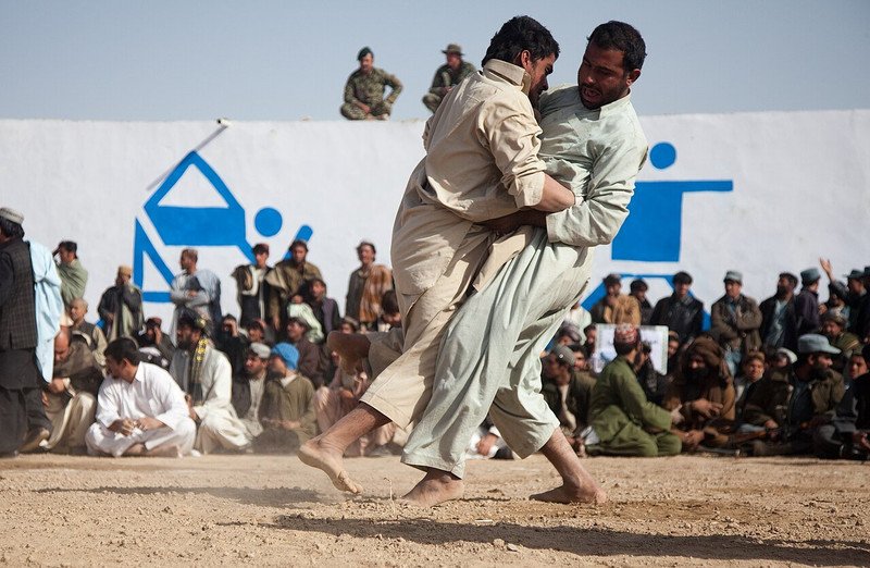 Two Afghan men compete at a traditional wrestling tournament in Zhari district in 2011