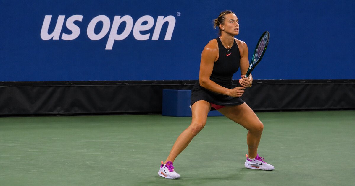 Aryna Sabalenka preparing to return serve on a US Open tennis court