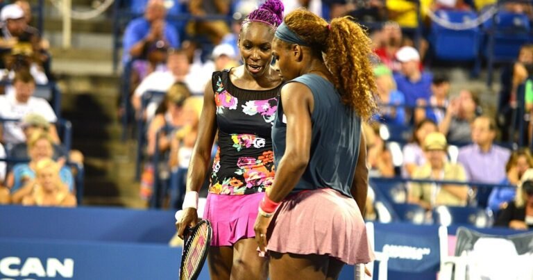 Serena Williams and Venus Williams confer during a US Open doubles match