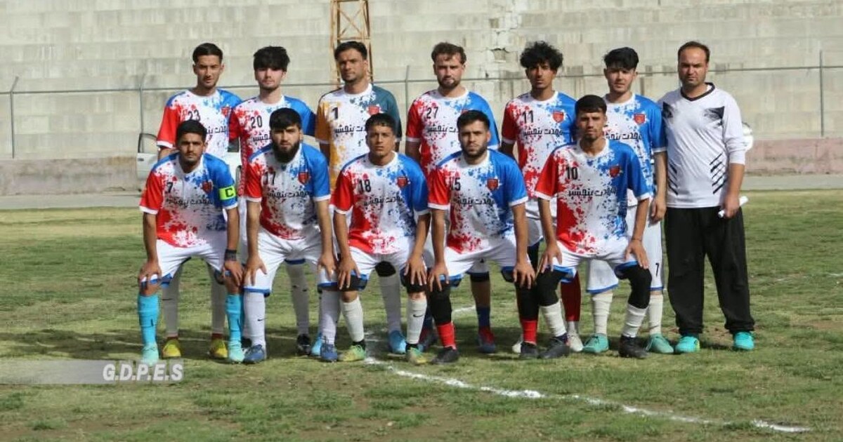 Wahdat Panjshir players and coach pose on the pitch after their provincial league campaign